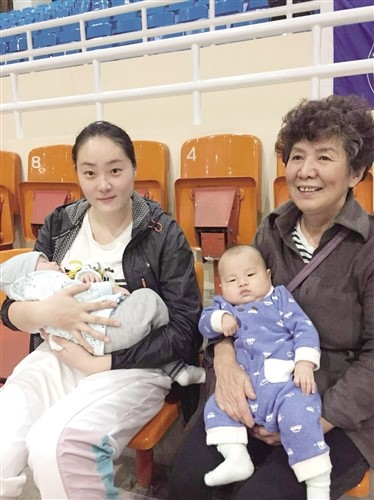 孙耀兰(图左)与李媚的妈妈抱着孩子坐在看台上观战 泰国东南亚3D彩票